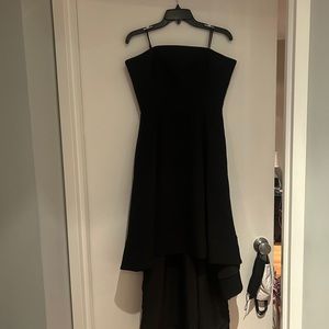 Black C/MEO COLLECTIVE. Short in the front, long in the back.